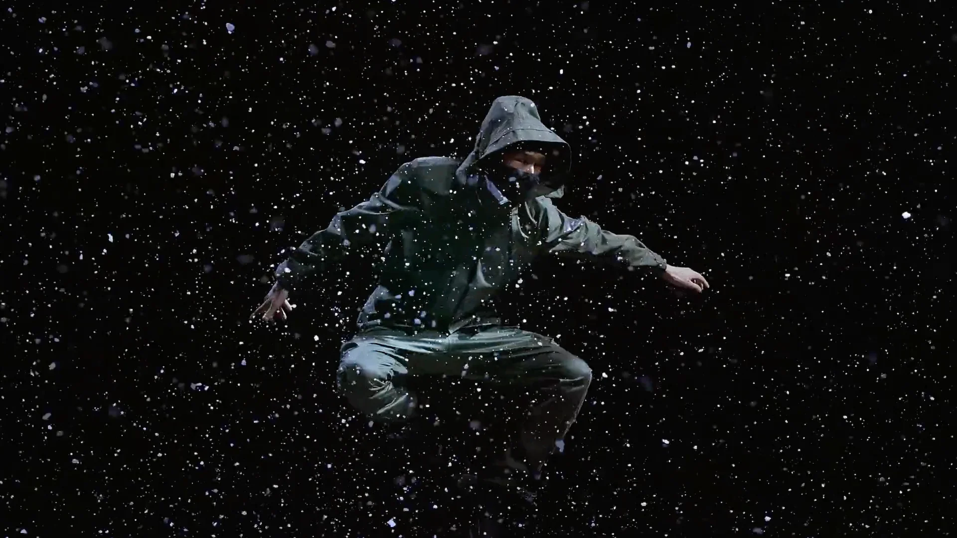 Nike film campaign still of a man dressed in ACG gear jumping in the middle of snowfall with black background by director Barnaby Roper Uturn PH